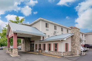 Traditional hotel with a two-story structure and stone facade, featuring a covered entrance with stone pillars.
