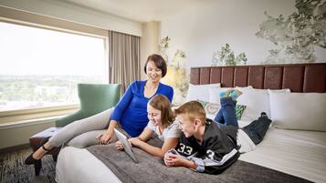 Relax in a spacious room with a large bed, city views, and a comfortable armchair.