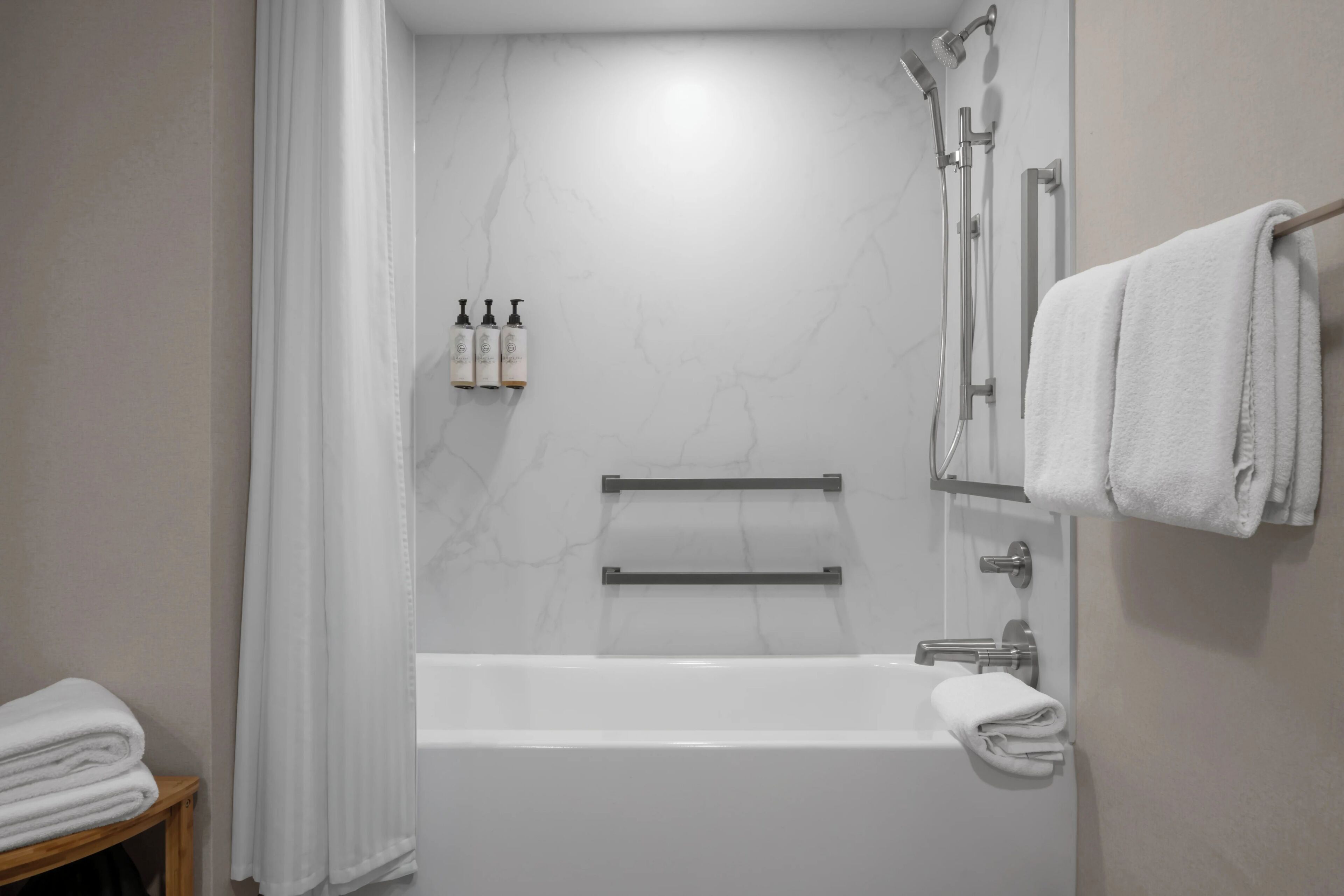 Une salle de bain moderne équipée d’une baignoire, d’une douche et d’un porte-serviettes.