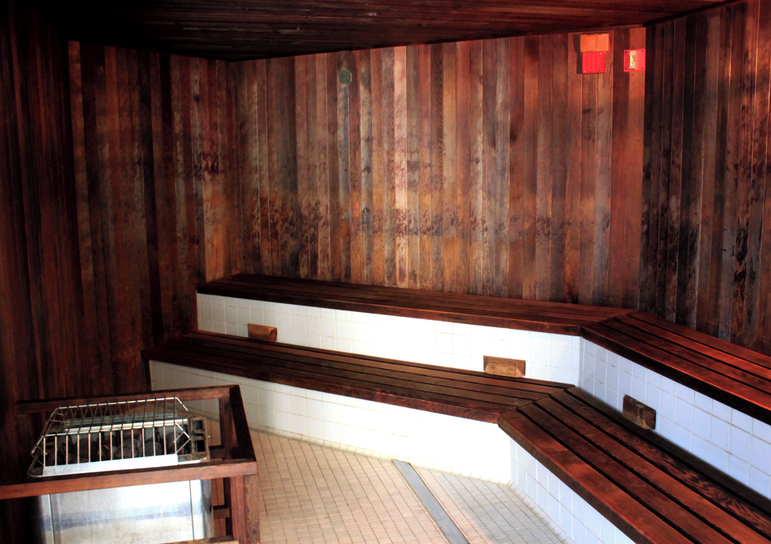 A wooden interior with a bench and a metal rack.