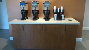 Un espace dédié au café, équipé de trois machines à café et d’un distributeur de sucre.