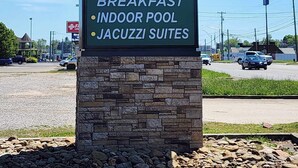 A sign for Quality Inn & Suites by Choice Hotels, highlighting amenities such as free breakfast, an indoor pool, and Jacuzzi suites.