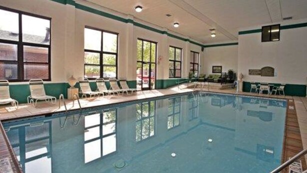 A swimming pool with lounge chairs and a sunshade area.