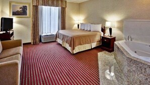 A hotel room with a bed, a TV, a desk, a lamp, a bathroom with a bathtub, and a window with curtains.