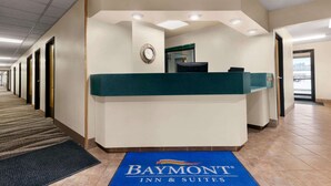 Zona de recepción con el cartel de Baymont Inn & Suites, un mostrador de recepción y suelo alfombrado.