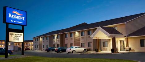 A Baymont motel with a signboard advertising heated indoor pool, hot breakfast, and welcome visitors.