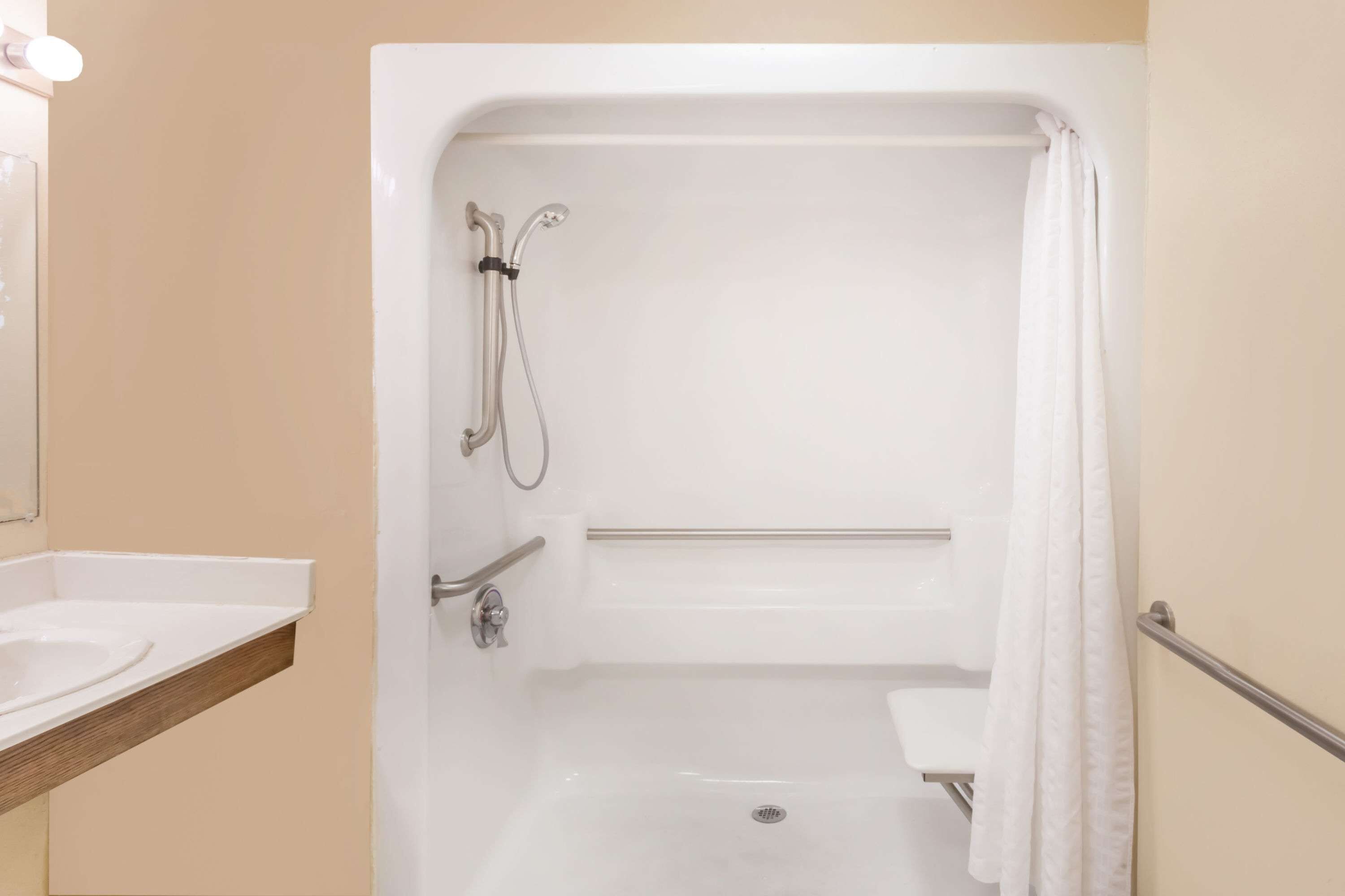 Un baño moderno con bañera, ducha y tocador con lavamanos.