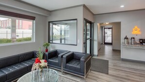 A modern hotel lobby with a black leather sofa, a glass coffee table, and a coffee station. - SureStay by Best Western Salt Lake City Downtown (Salt Lake City)