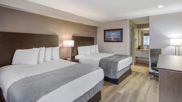 A hotel room with two beds, a desk, a chair, and a framed picture on the wall. - SureStay by Best Western Salt Lake City Downtown (Salt Lake City)