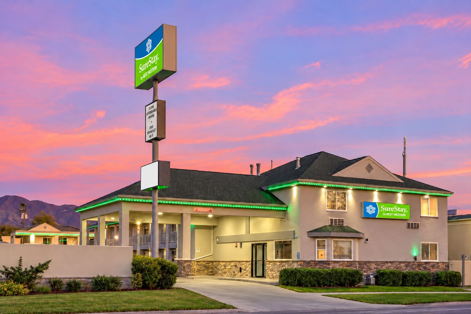 A hotel with a sign indicating it is a SureStay by Best Western, featuring a clean affordable stay, free breakfast, and Wi-Fi.