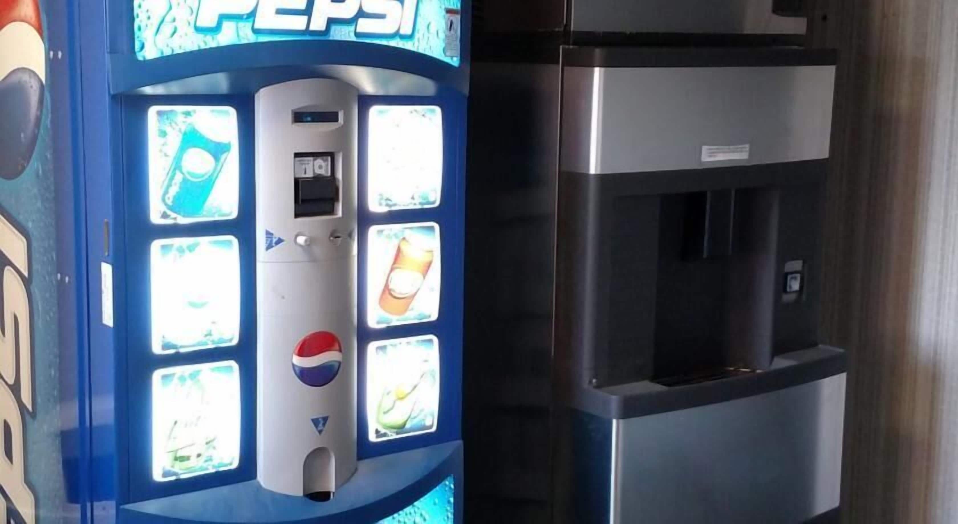 A vending machine with a Pepsi logo and a water dispenser next to it.