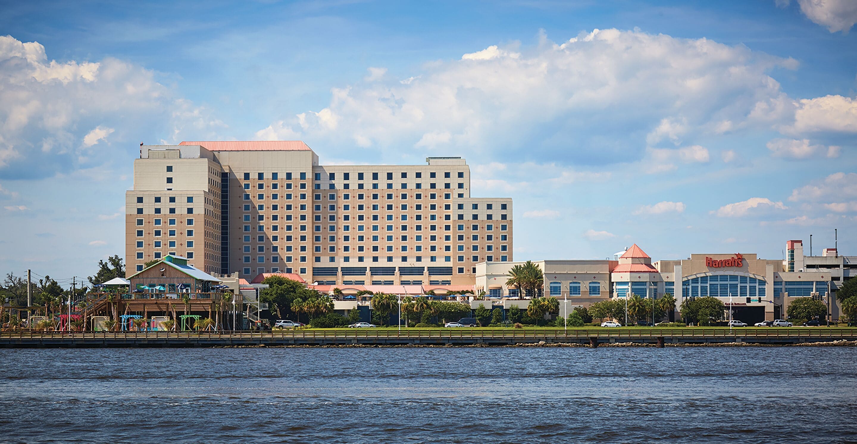 Een groot hotel met meerdere verdiepingen en een opvallend gebouw aan de overkant van het water.
