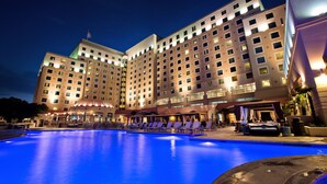 A hotel with a large pool area, multiple balconies, and a well-lit facade. - Harrah's Gulf Coast Hotel & Casino - A Caesars Rewards Destination (Biloxi)