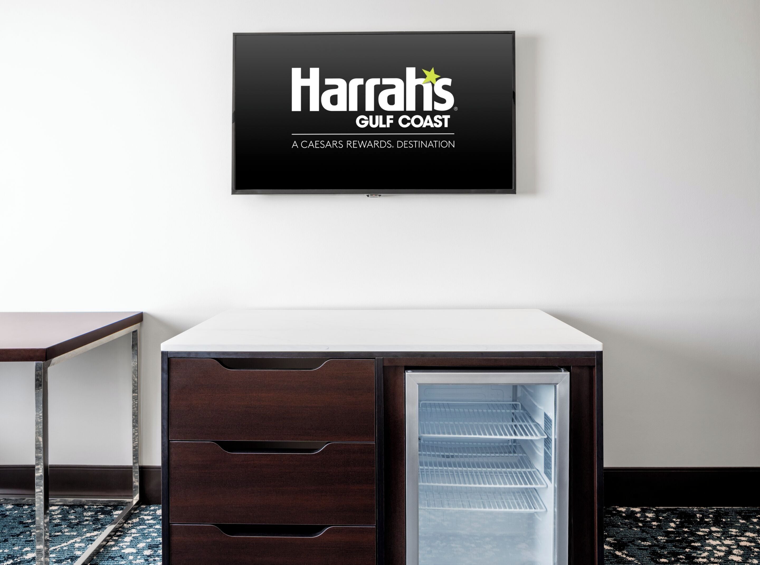 A Harrah's Gulf Coast room with a flat-screen TV, a minibar, and a patterned carpet.