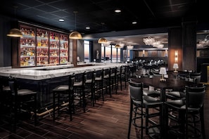A bar area with a marble countertop, multiple seating arrangements, and a view of the sunset. - Harrah’s Gulf Coast – A Caesars Rewards Destination (Biloxi)