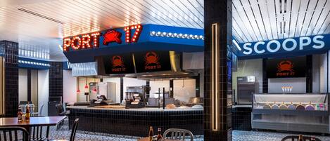 A restaurant interior with a counter, seating area, and a display case.