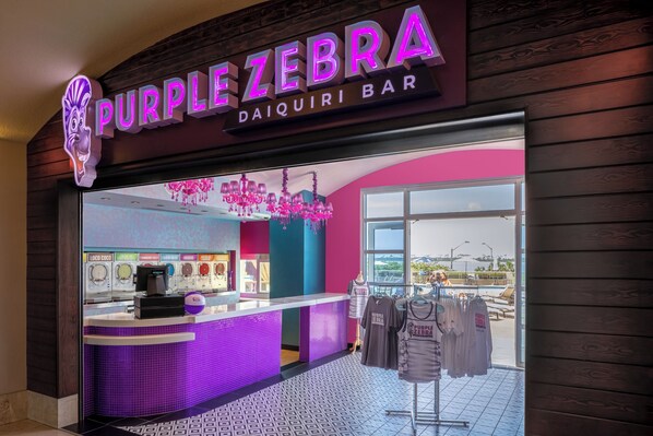 A bar named Purple Zebra with a neon sign, a counter with a coffee machine, and a window view. - Harrah's Gulf Coast Hotel & Casino - A Caesars Rewards Destination (Biloxi)