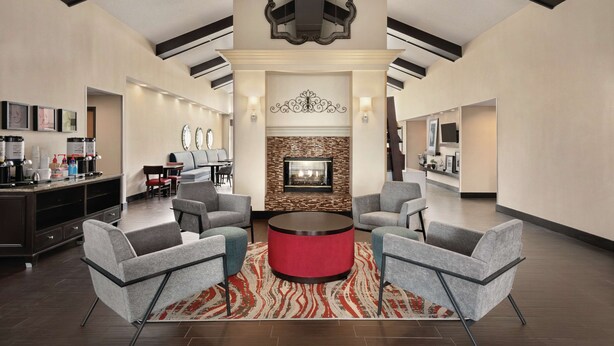 A spacious lobby with a fireplace, comfortable seating, and a coffee station.