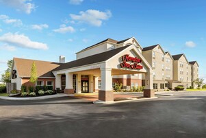 A Hampton Inn & Suites hotel with a covered front entrance, multiple guest rooms, and a parking lot.