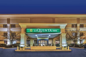 The exterior of La Quinta Inn with a prominent entrance, a covered walkway, and a landscaped area with trees. - La Quinta Inn by Wyndham Toledo Perrysburg (Perrysburg)