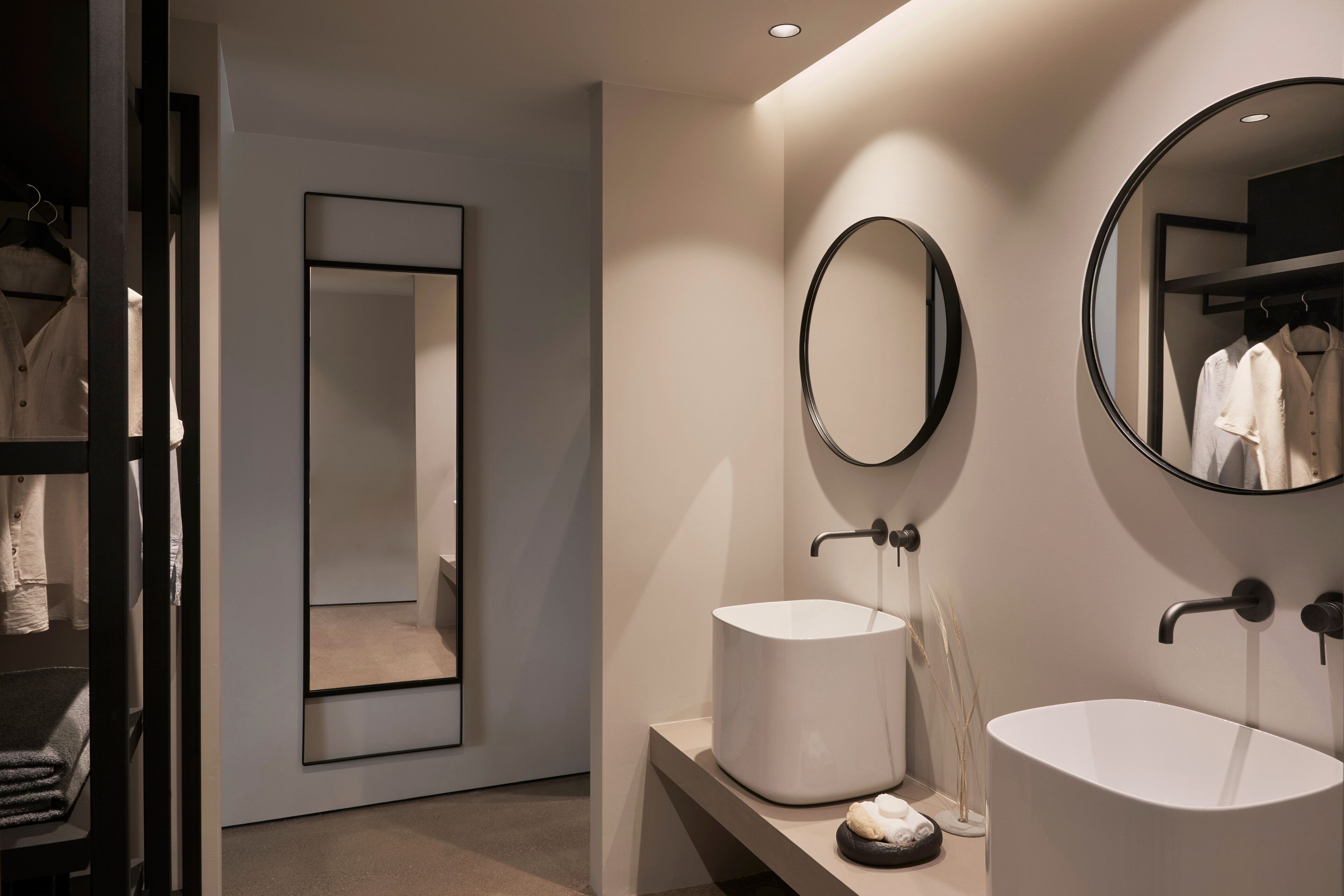 Un bagno moderno con due lavabi, uno specchio grande e un portasciugamani.