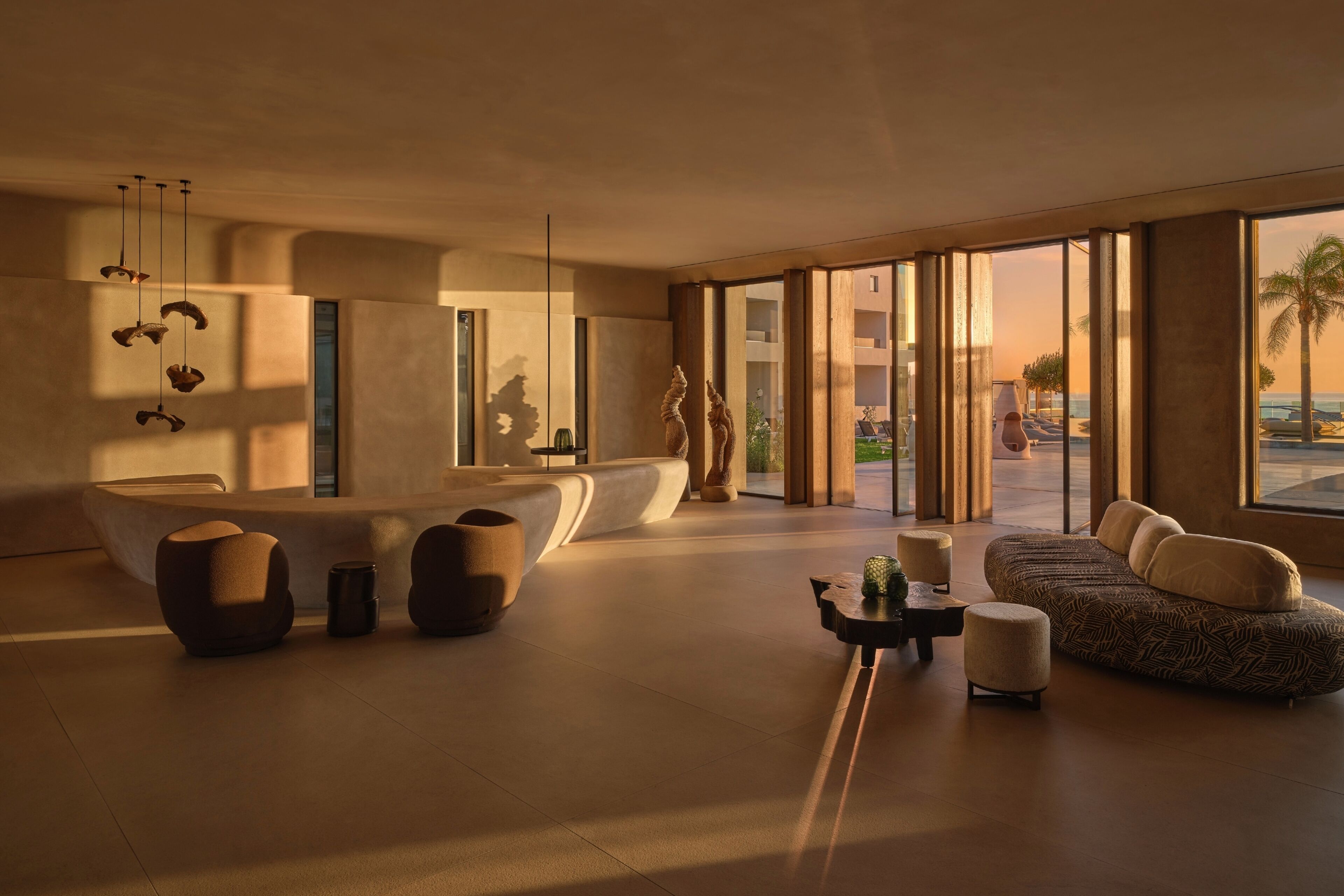 Een modern interieur met een bank, voetenbankje en hangende lampen.