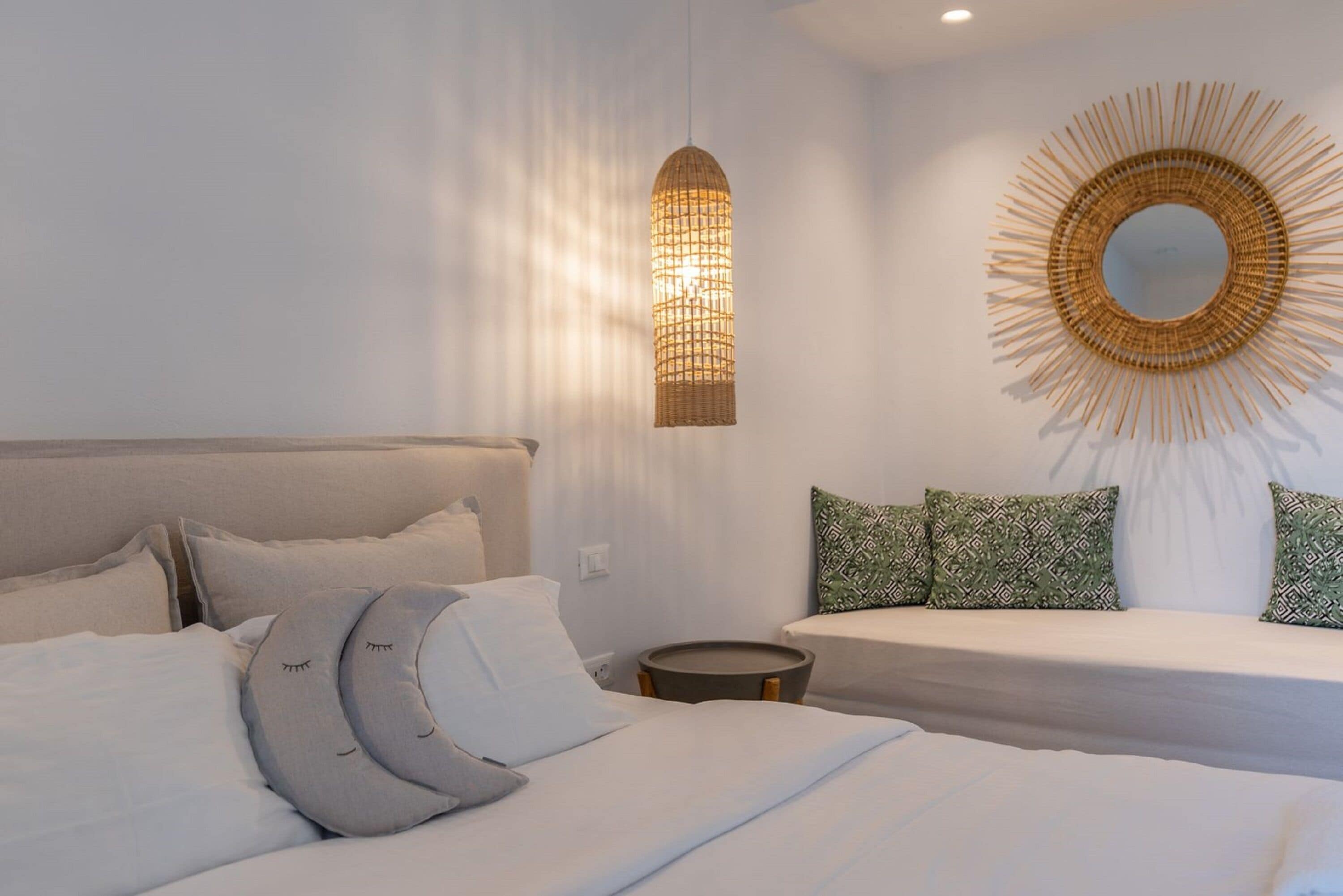 Un dormitorio moderno con una cama grande, una mesita de noche y un espejo montado en la pared.
