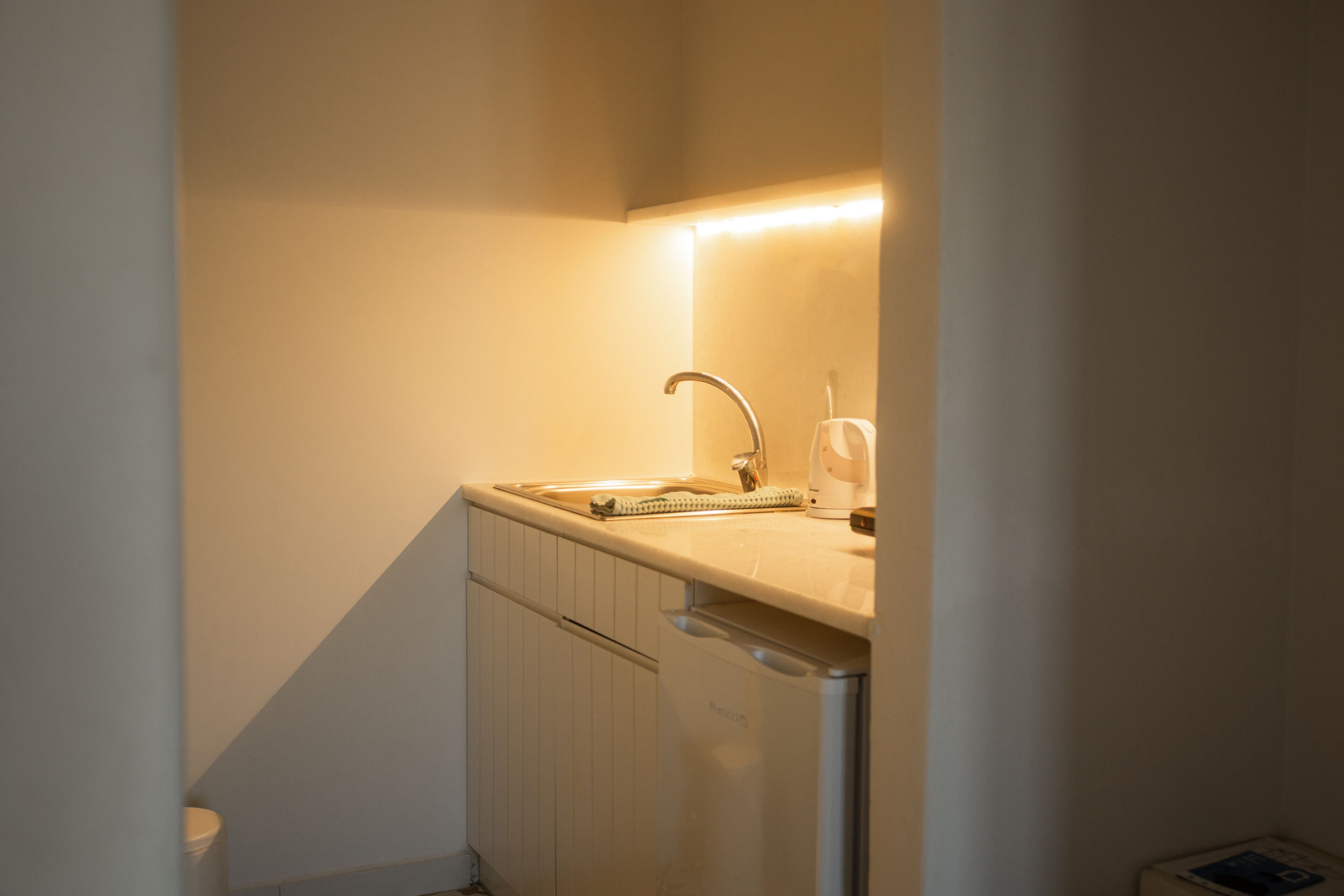Une petite salle de bain avec un lavabo, un miroir et un porte-serviettes.