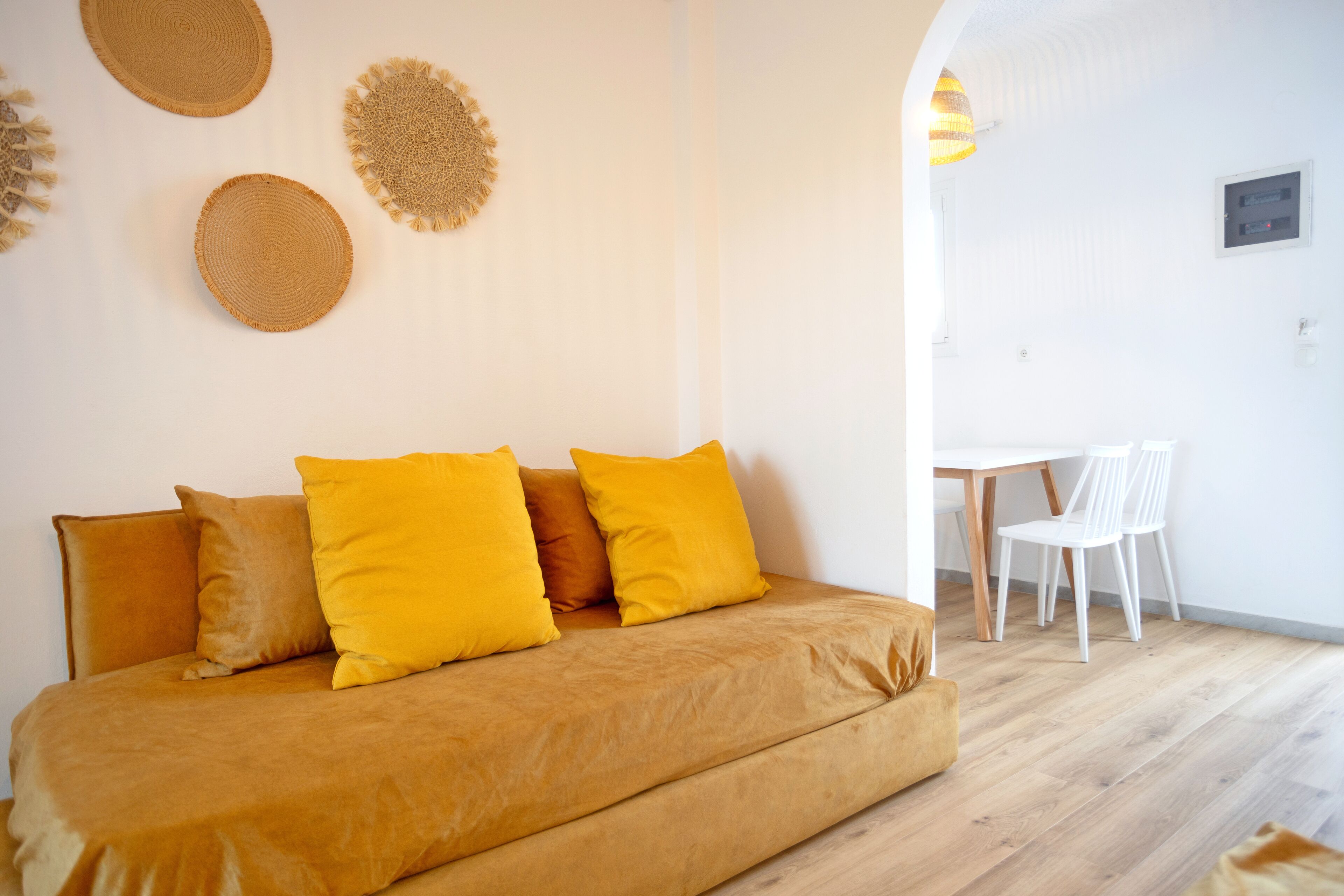 Una habitación con sofá cama, una mesa de comedor con sillas y decoración en las paredes.