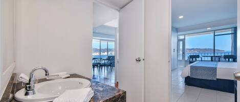 A modern bathroom with a sink, mirror, and towel.