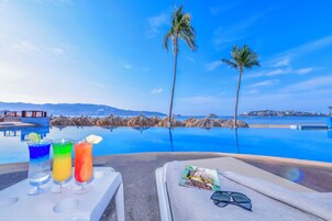 Una piscina al aire libre, sillones reclinables de piscina