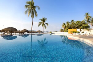 Una piscina al aire libre, sillones reclinables de piscina