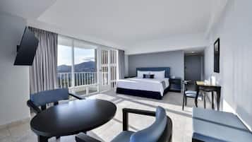 Ein modernes Hotelzimmer mit Bett, Schreibtisch, Stuhl und Tisch.