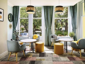 A room with a large window, a round table, and two armchairs. - ibis Styles Bournemouth (Bournemouth)
