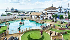 A water park with a pool, wooden play structures, and a bridge over the water. - ibis Styles Bournemouth (Bournemouth)