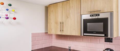 A compact kitchen with a sink, a microwave, and a dishwasher.
