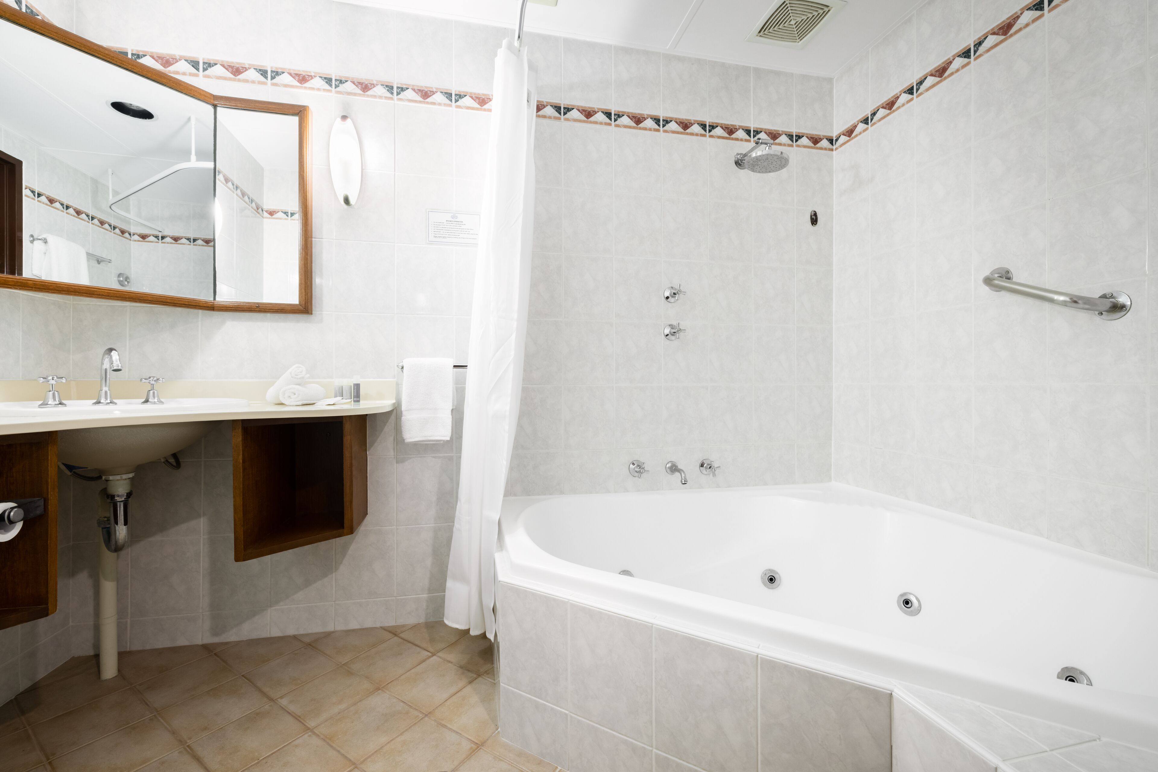 A modern bathroom with a sink, mirror, shower, and bathtub.