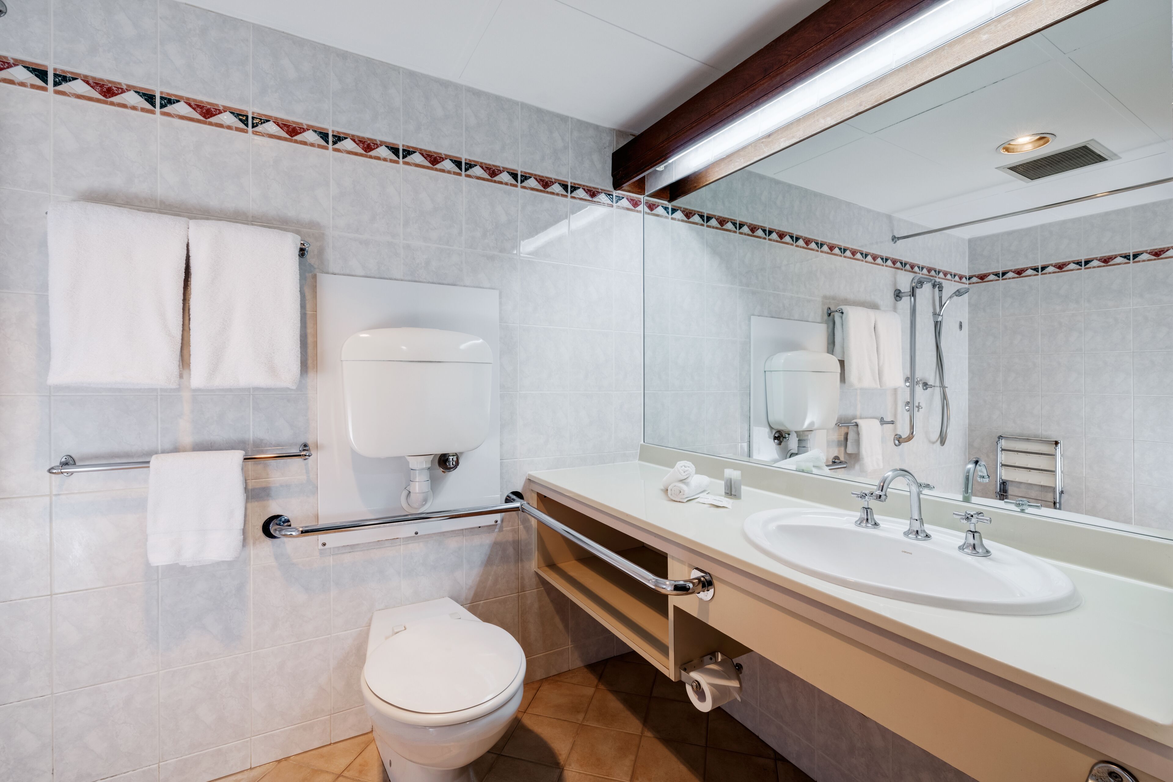 A modern bathroom with a toilet, sink, and shower.