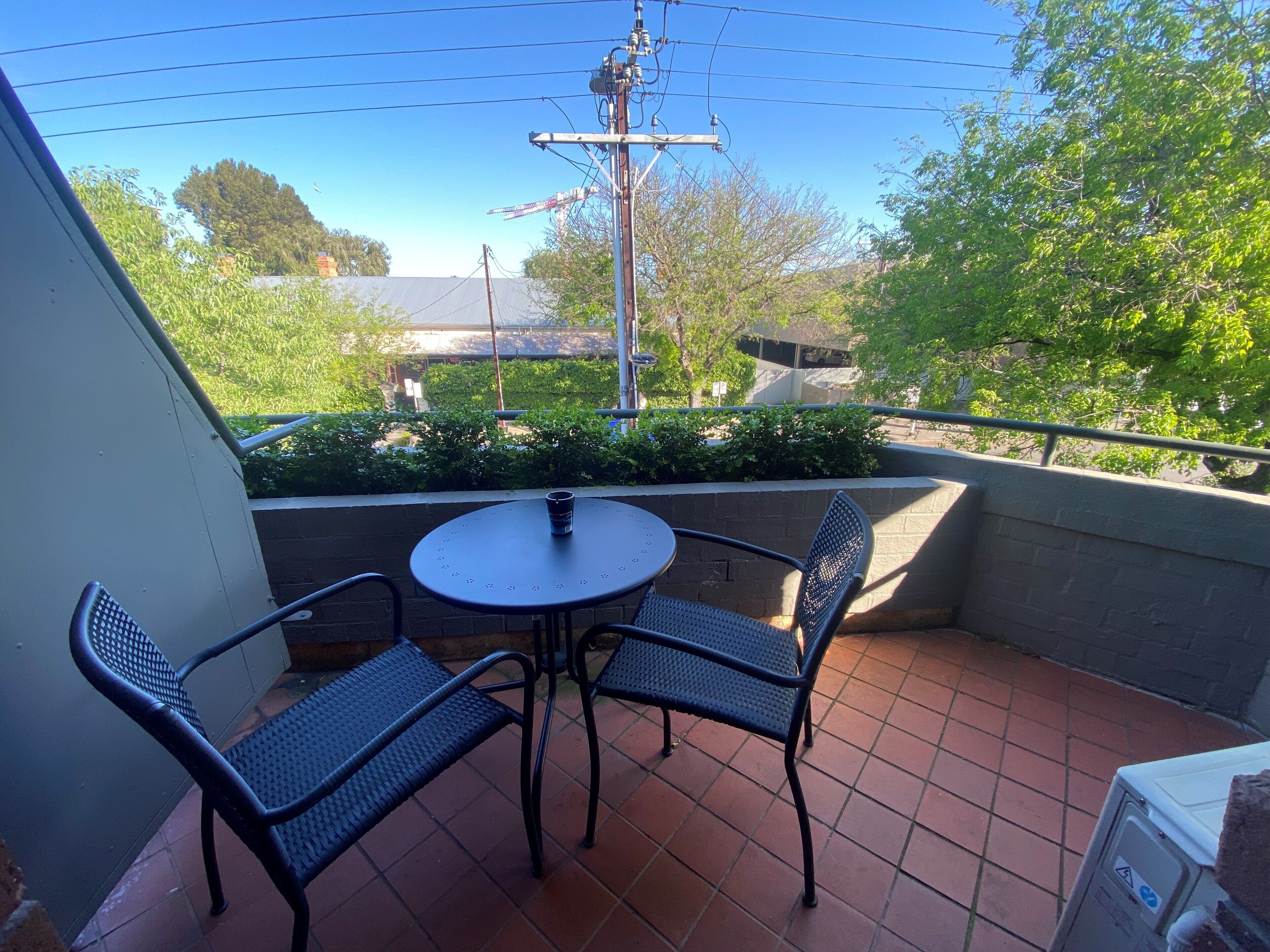 Eine kleine Terrasse mit einem runden Tisch und zwei Stühlen.