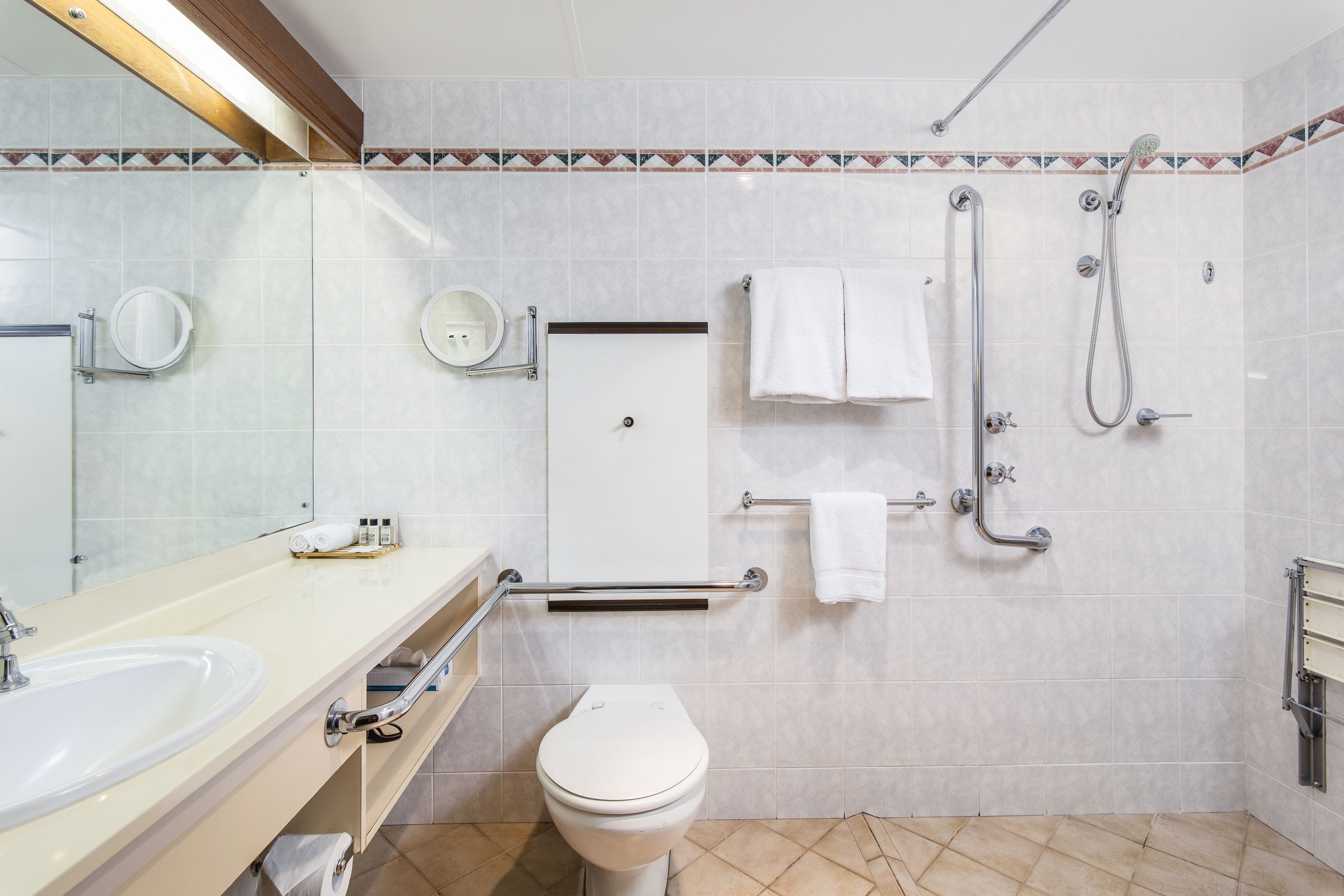 A modern bathroom with a sink, toilet, and shower.