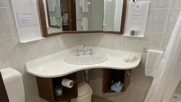 A bathroom with a white sink, mirror, and toilet. There are two towel racks and a shower curtain.