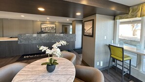 A modern reception area with a marble reception desk, a welcome mat, a framed picture, and a window with a view. - Super 8 by Wyndham Lethbridge (Lethbridge)