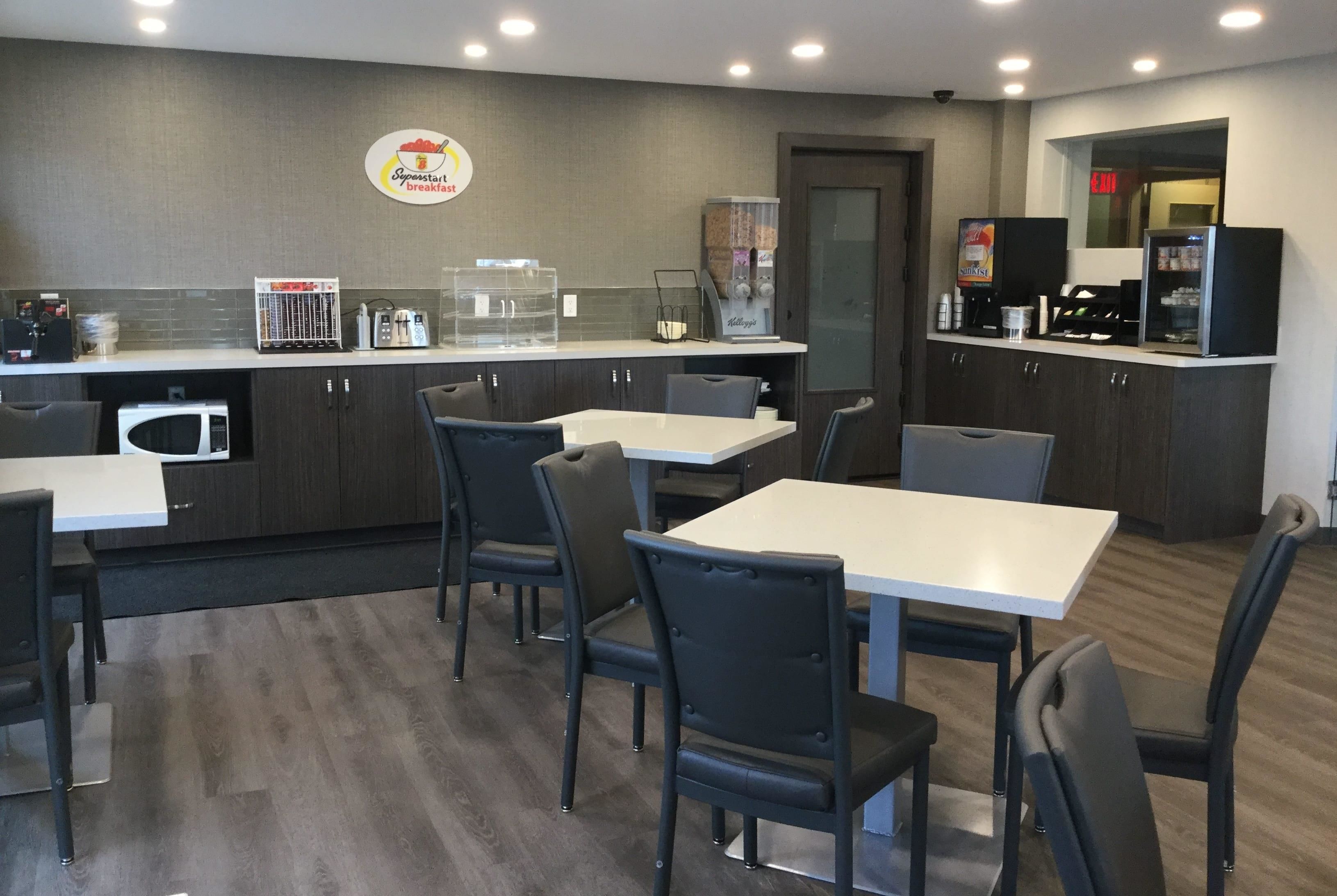 A modern breakfast area with a counter, seating, and kitchen appliances.