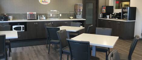 A modern breakfast area with a counter, seating, and kitchen appliances.