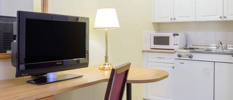 Une cuisine moderne équipée d’un téléviseur à écran plat, d’une lampe, d’un four à micro-ondes et d’un lave-vaisselle.