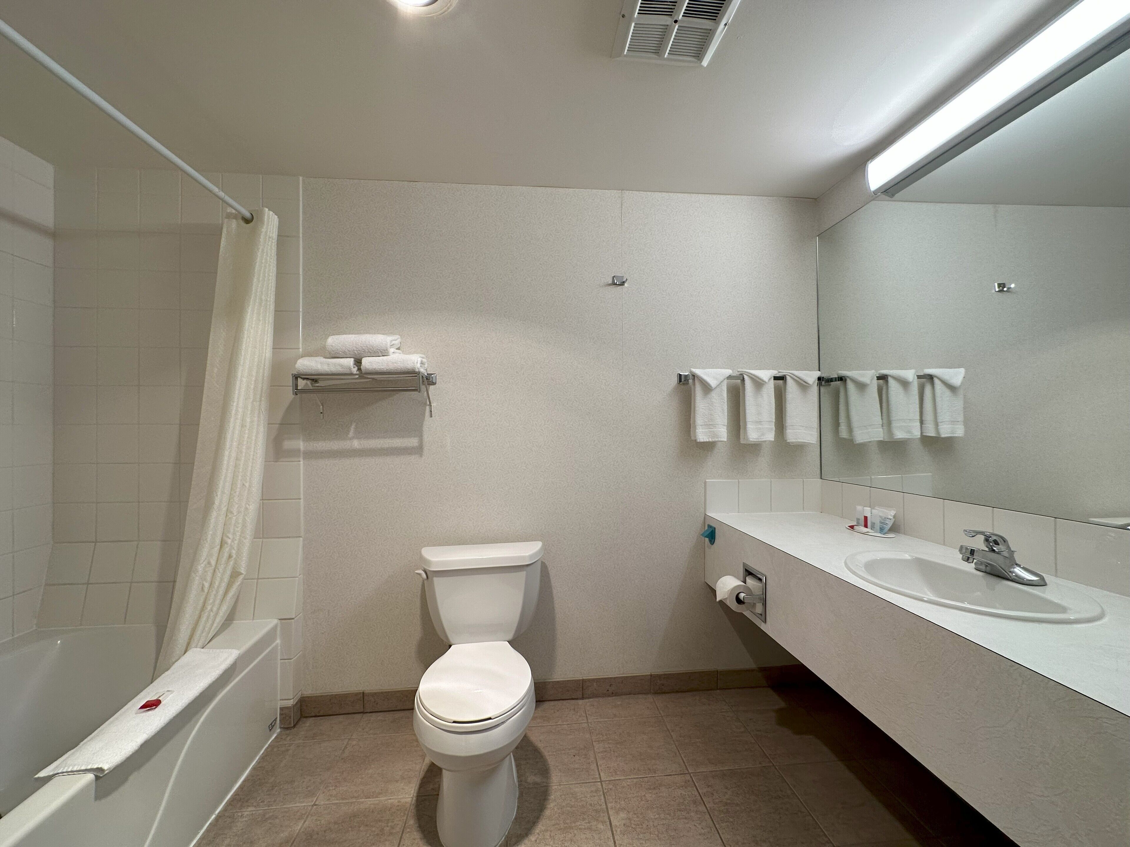 A modern bathroom with a toilet, sink, and shower.