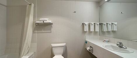 A modern bathroom with a toilet, sink, and shower.