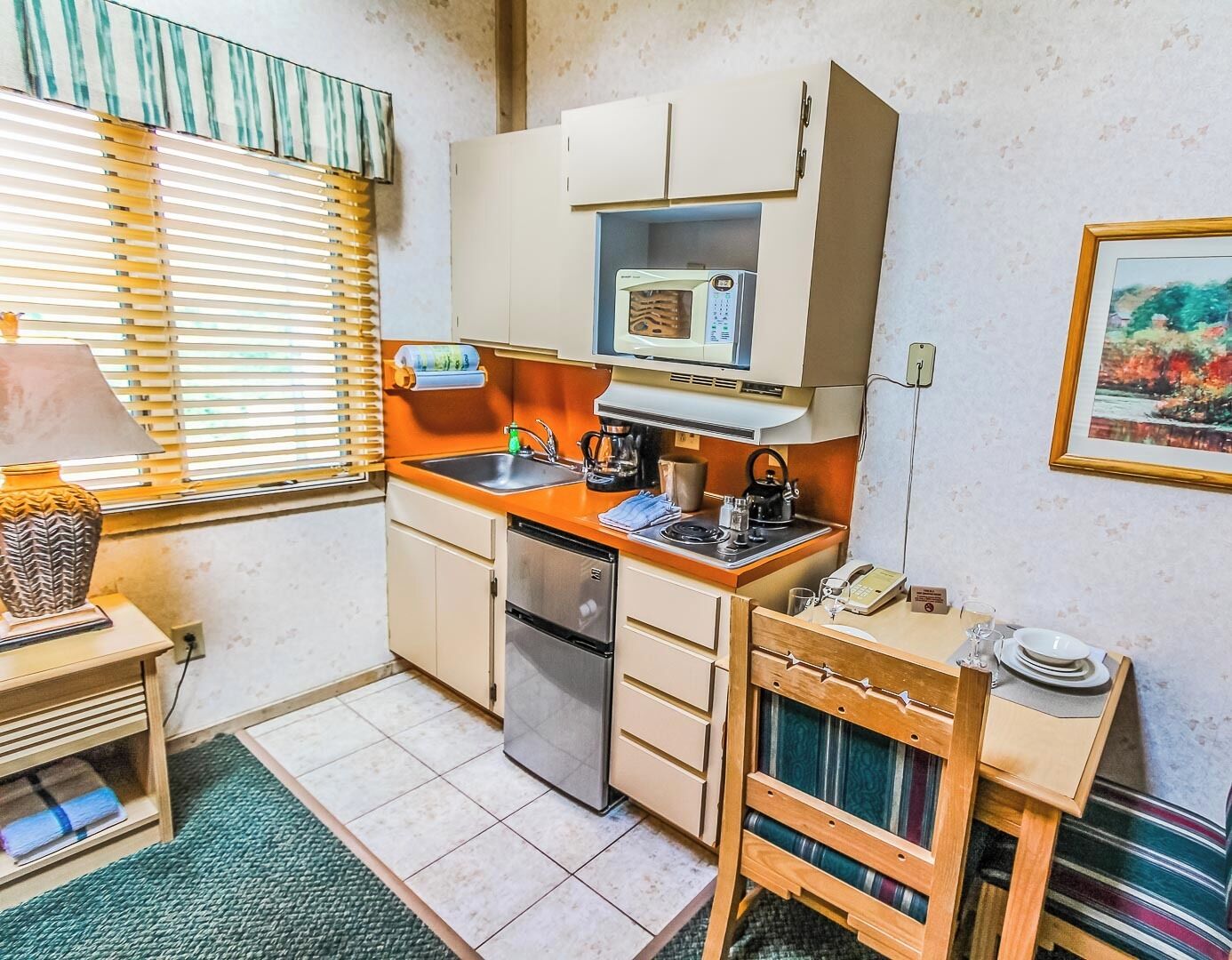 A compact kitchen with a microwave, sink, and a small refrigerator.