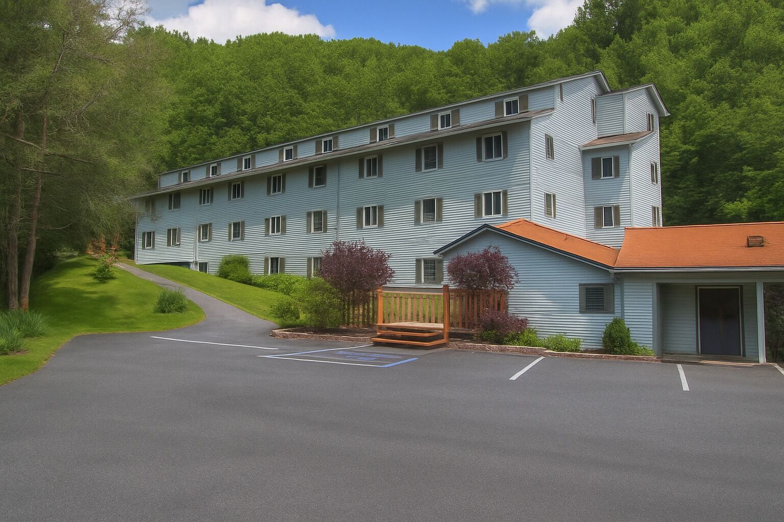 A multi-story building with a parking lot and a small porch area.