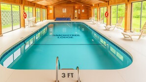 A swimming pool at Smoketree Lodge with a 3 ft depth marker, wooden interior, and outdoor views.